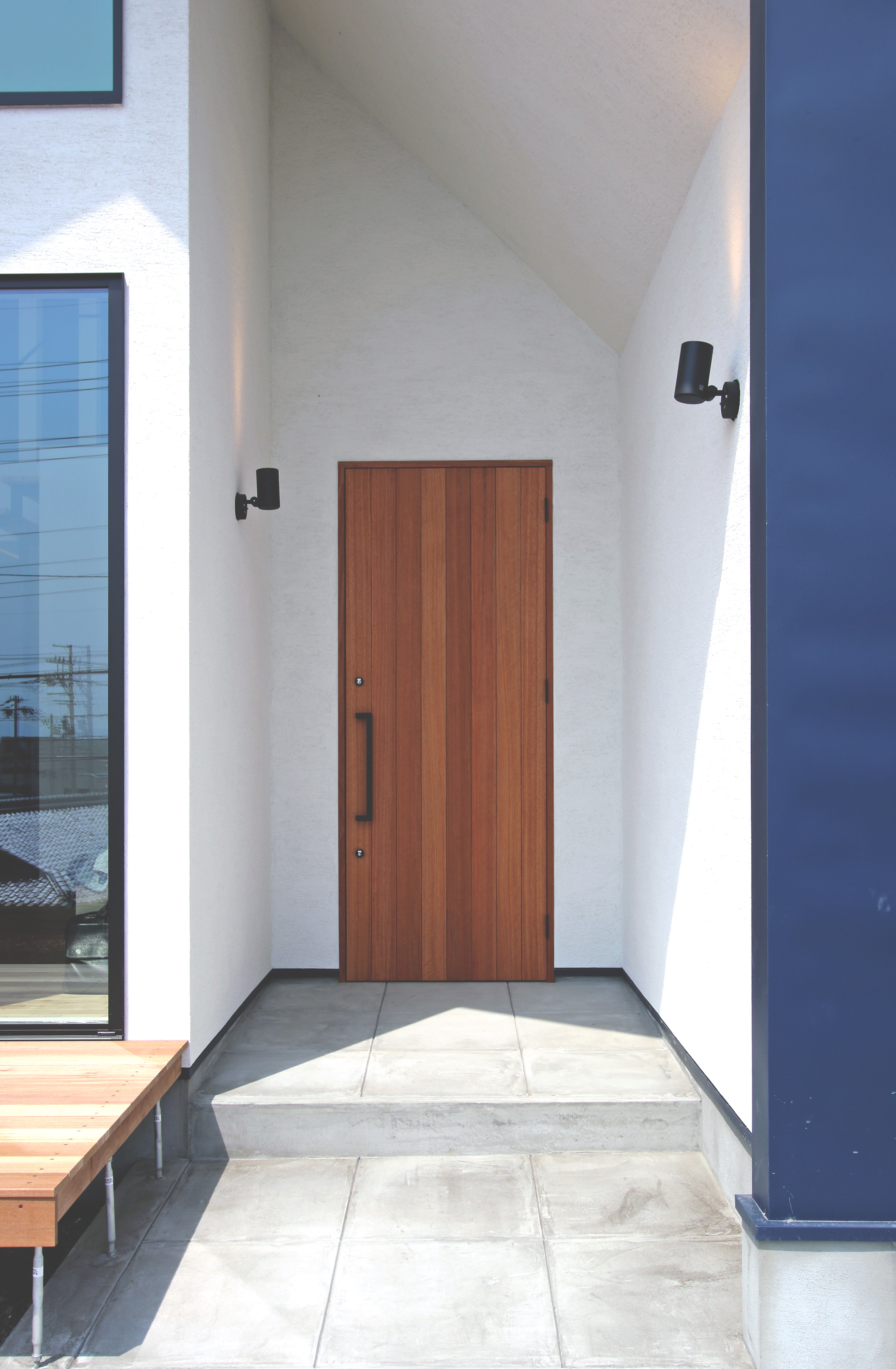 蒼ガルバリウムと白モルタル塗り壁のコントラストが美しい家