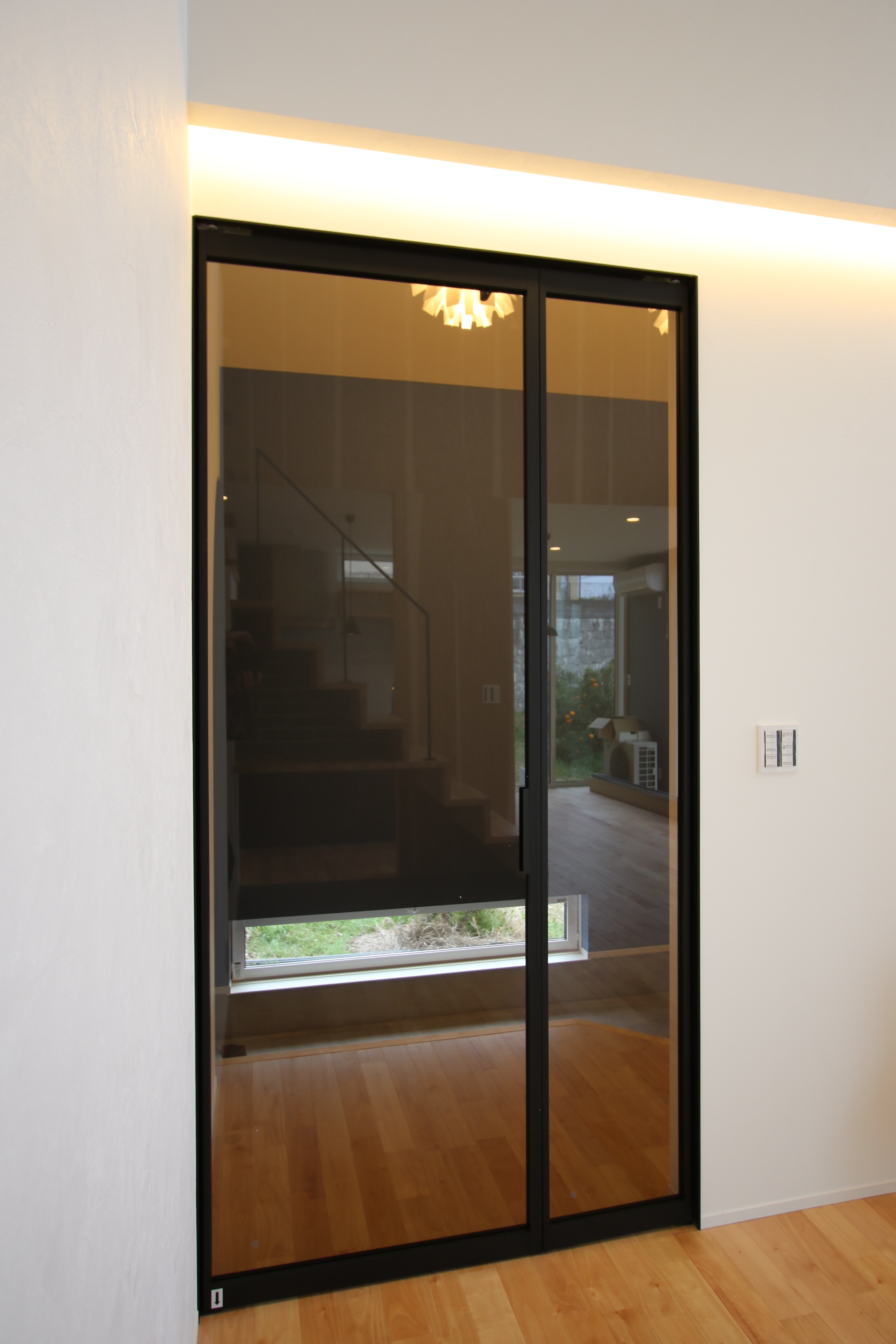 蒼ガルバリウムと白モルタル塗り壁のコントラストが美しい家